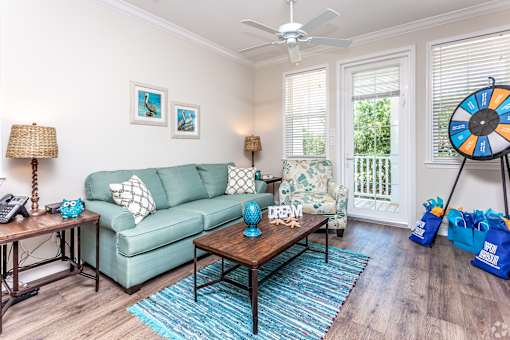 A living room with a green couch and a blue rug.