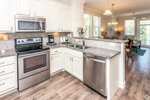 A kitchen with a stove, oven, microwave, and sink.