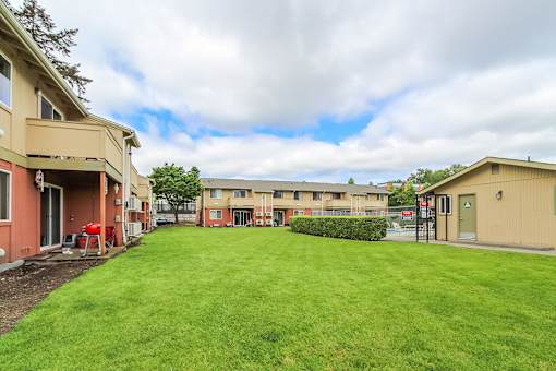 A grassy area in front of apartment buildings.
