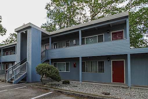 A blue building with a red door and windows.