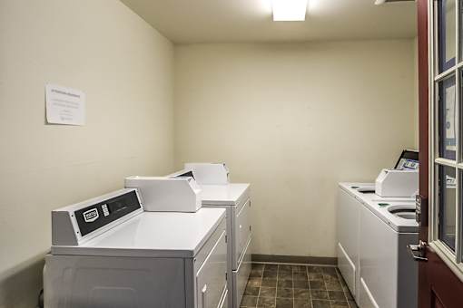 A white wall with a paper on it and a washing machine.