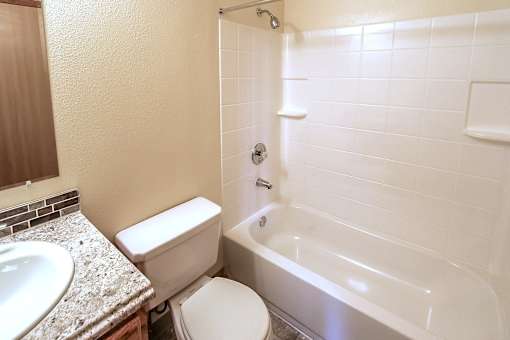 A white toilet sits next to a sink in a small bathroom.