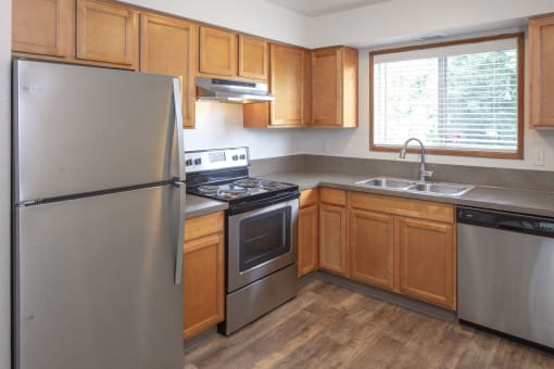 a kitchen with wooden cabinets and stainless steel appliances