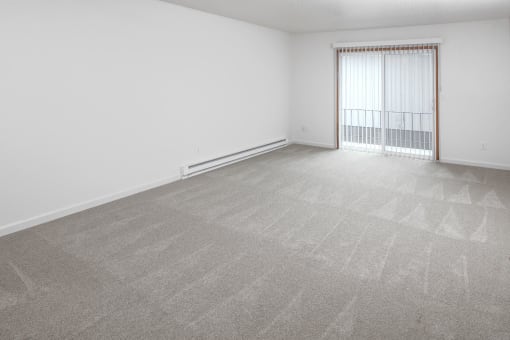 a bedroom with a large window and a carpeted floor