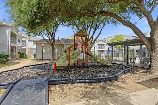 A playground with a green slide and a red stand.
