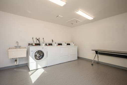 A laundry room with a washing machine and a sink.