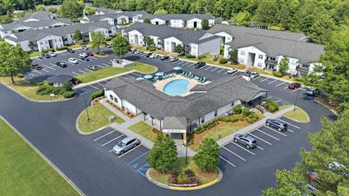 A large building with a pool in the middle of a parking lot.