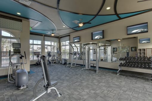 Free weights, benches, and other fitness equipment in fitness center at Lake Nona Water Mark in Orlando, FL 32827