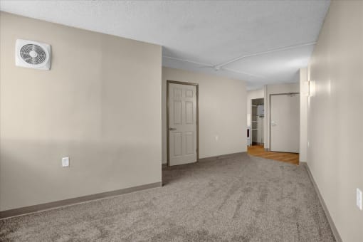 a living room with a white door and a carpeted floor