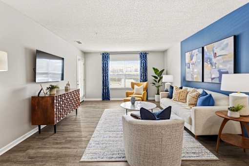 A living room with a white couch, a wooden cabinet, and a rug.