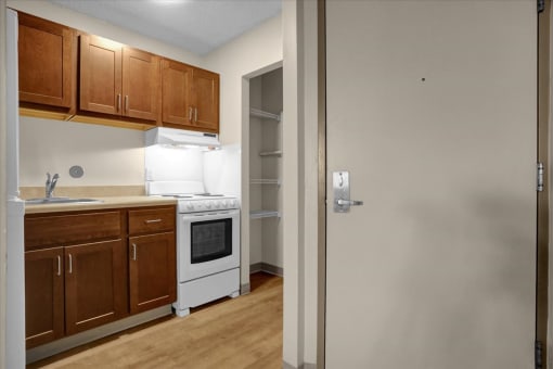 a kitchen with wooden cabinets and a white stove and refrigerator