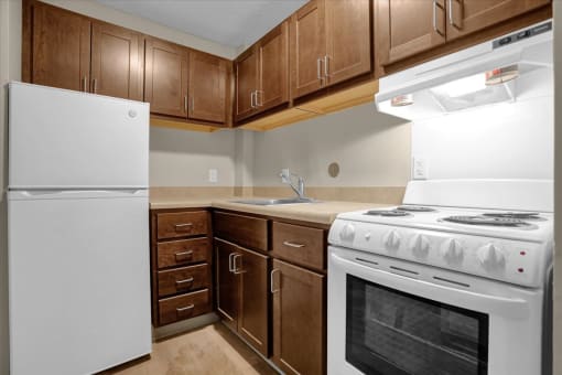 a kitchen with white appliances and wooden cabinets