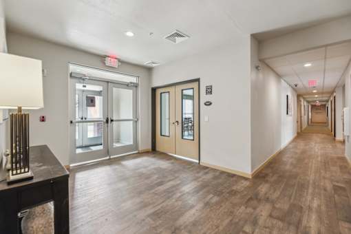 A hallway with a wooden floor and white walls.