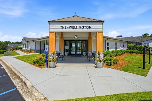 The Wellington building has a white and orange facade with a blue sign above the entrance.