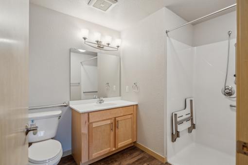 A bathroom with a toilet, sink, and shower.