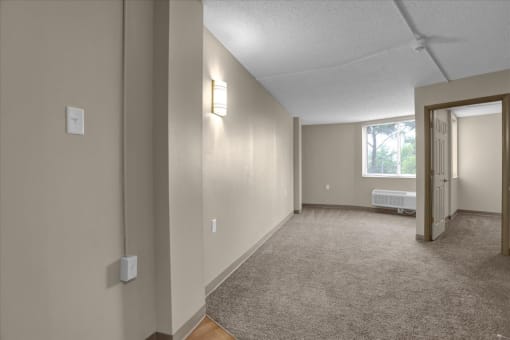 an empty living room with a door to a bedroom