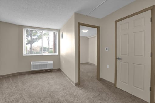 an empty bedroom with a window and a door