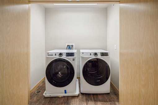 Two front loading washing machines in a small laundry room.