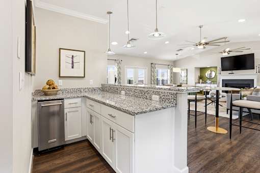 A modern kitchen with a granite countertop and stainless steel appliances.