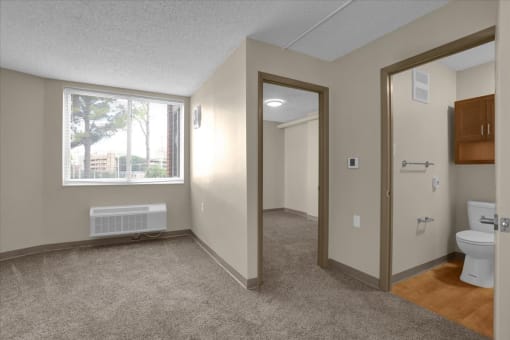 a bathroom with a window and a toilet and a mirror
