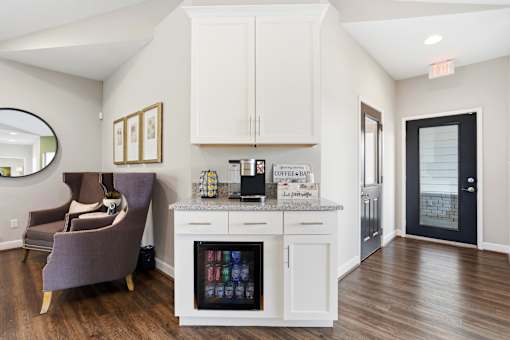 A kitchen with a purple chair and a fridge with a glass door.