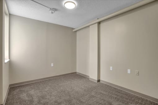 an empty room with white walls and a carpeted floor