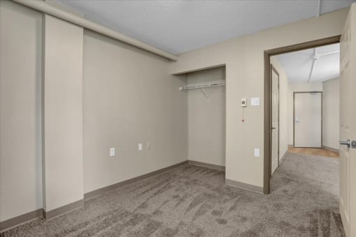 the living room of an apartment with a door to the closet