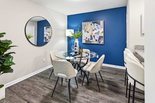A dining room with a glass table and chairs.