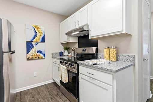 A kitchen with a stove top oven and a refrigerator.