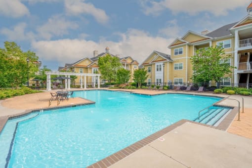 large pool and lounge area surrounded by trees and apartment homes at Fenwyck Manor