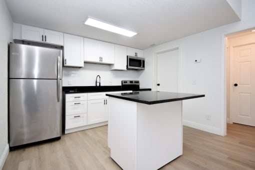 a kitchen with white cabinets and a stainless steel refrigerator
