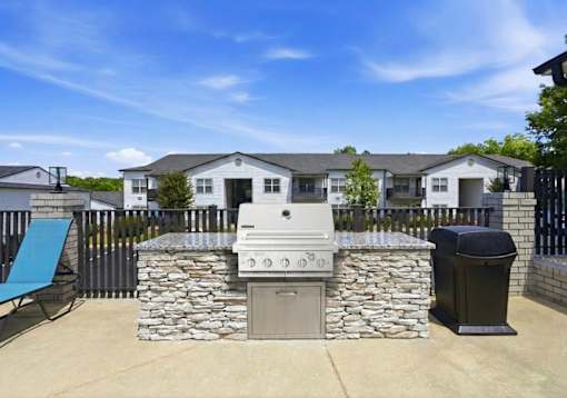 A stone fireplace is in the middle of a patio.