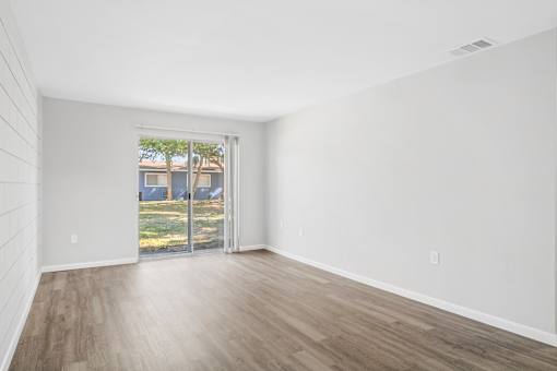 A room with a sliding glass door leading to a backyard.