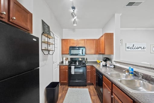 a Centerville Manor kitchen with wood cabinets and black appliances