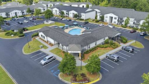 A large building with a pool in the middle of a parking lot.