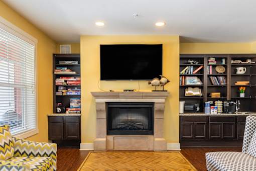 A living room with a fireplace and a television mounted on the wall.