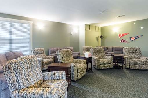 A room with a carpeted floor and a row of chairs.