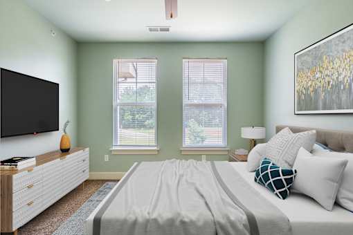A bedroom with a bed, a dresser, and a television.