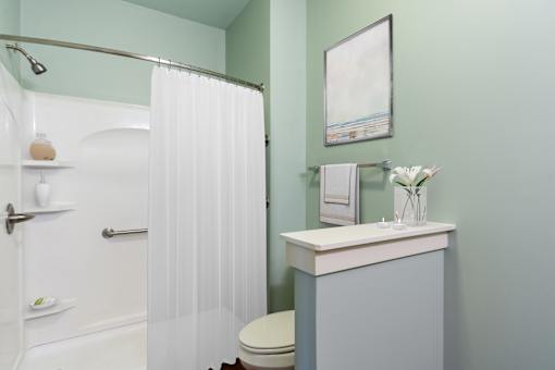 A white toilet sits next to a white sink in a bathroom.