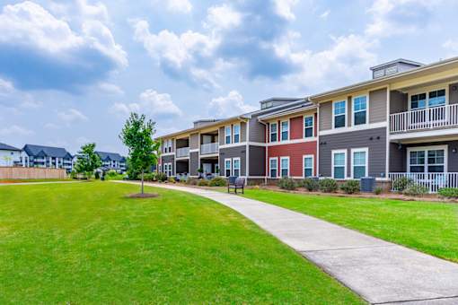 A row of houses with a green lawn in front.