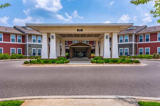 A building with a covered walkway entrance and a sign above it.