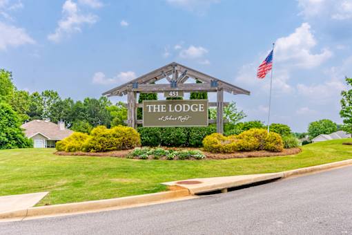 A sign for The Lodge at Pine Ridge stands in front of a green lawn.