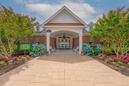 entrance to Fenwyck Manor Clubhouse with neat walkway and lush, mature landscaping