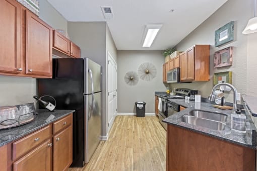 Fenwyck Manor Apartment home kitchen with wood cabinets, granite countertops, and stainless steel appliances