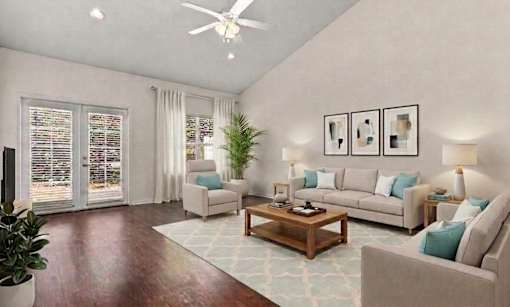 A living room with a couch, chair, and potted plant.