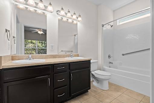 A bathroom with a sink, mirror, and toilet.