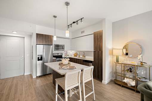 A modern kitchen with a dining table and chairs.