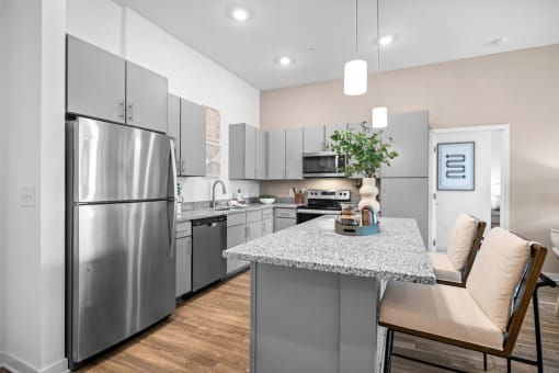 a kitchen with stainless steel appliances and a marble counter top