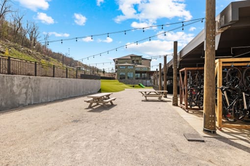 a seating area with picnic tables and bikes in front of a building