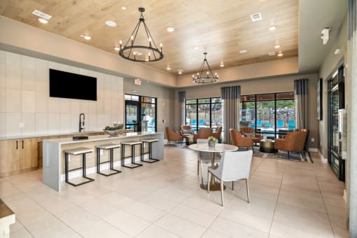 the lobby of a clubhouse with a table and chairs